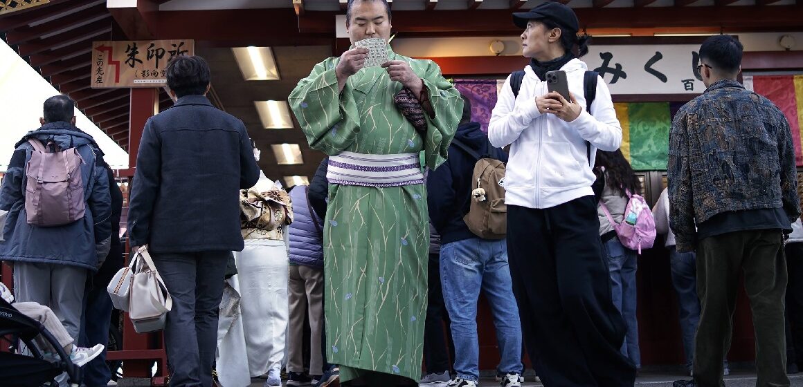 Les visiteurs vérifient les « Omikuji » ou bandes de papier révélatrices de bonnes aventures au temple bouddhiste Sensoji du district d'Asakusa, le mercredi 18 décembre 2024, à Tokyo. Photo : Eugene Hoshiko / Sipa