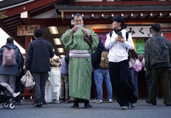 Les visiteurs vérifient les « Omikuji » ou bandes de papier révélatrices de bonnes aventures au temple bouddhiste Sensoji du district d'Asakusa, le mercredi 18 décembre 2024, à Tokyo. Photo : Eugene Hoshiko / Sipa