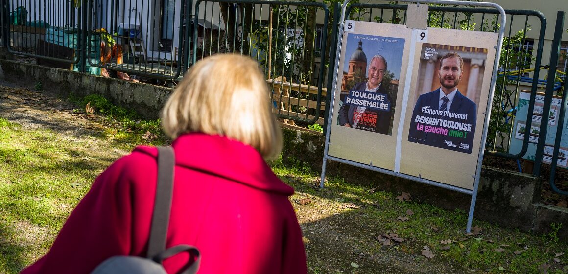 Toulouse, 20 mars 2026. Une personne regarde les panneaux électoraux en vue du second tour des élections municipales le 22 mars 2026 avec l’actuel Maire de Toulouse Jean Luc Moudenc (G) et Francois Piquemal pour LFI (D). Photo : Frédéric Scheiber / Hans Lucas via AFP Toulouse, 20 mars 2026. Une personne regarde les panneaux électoraux en vue du second tour des élections municipales le 22 mars 2026 avec l’actuel Maire de Toulouse Jean Luc Moudenc (G) et Francois Piquemal pour LFI (D). Photo : Frédéric Scheiber / Hans Lucas via AFP