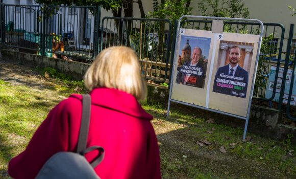 Toulouse, 20 mars 2026. Une personne regarde les panneaux électoraux en vue du second tour des élections municipales le 22 mars 2026 avec l’actuel Maire de Toulouse Jean Luc Moudenc (G) et Francois Piquemal pour LFI (D). Photo : Frédéric Scheiber / Hans Lucas via AFP Toulouse, 20 mars 2026. Une personne regarde les panneaux électoraux en vue du second tour des élections municipales le 22 mars 2026 avec l’actuel Maire de Toulouse Jean Luc Moudenc (G) et Francois Piquemal pour LFI (D). Photo : Frédéric Scheiber / Hans Lucas via AFP