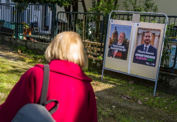 Toulouse, 20 mars 2026. Une personne regarde les panneaux électoraux en vue du second tour des élections municipales le 22 mars 2026 avec l’actuel Maire de Toulouse Jean Luc Moudenc (G) et Francois Piquemal pour LFI (D). Photo : Frédéric Scheiber / Hans Lucas via AFP Toulouse, 20 mars 2026. Une personne regarde les panneaux électoraux en vue du second tour des élections municipales le 22 mars 2026 avec l’actuel Maire de Toulouse Jean Luc Moudenc (G) et Francois Piquemal pour LFI (D). Photo : Frédéric Scheiber / Hans Lucas via AFP
