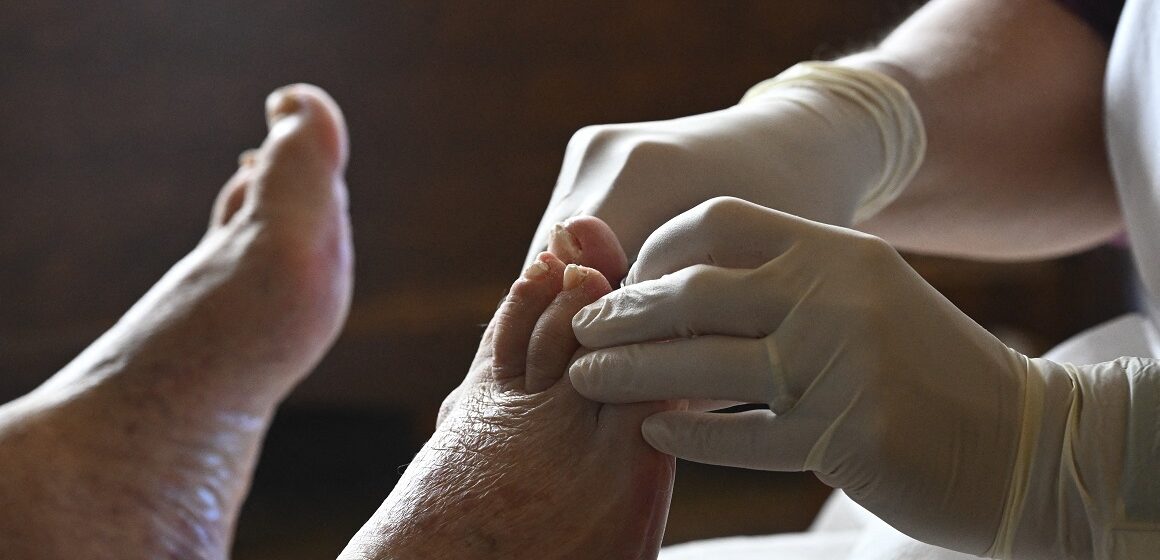 FRANCE - PARIS - SENIOR- ILLUSTRATION Une aide-soignante soigne le pied d’une personne âgée lors d’une visite à domicile, reflet du besoin croissant de soutien médical à domicile pour les personnes agées. Paris. 17 octobre 2025. Photo : Eric Beracassat / Hans Lucas via AFP