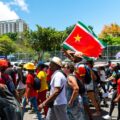 Des manifestants, brandissent le drapeau régional guadeloupéen, lors d'un défilé du 1er Mai (Fête du Travail), le 1er mai 2023. Photo : Lara Balais / AFP