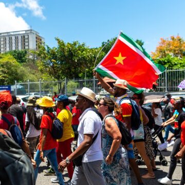 Des manifestants, brandissent le drapeau régional guadeloupéen, lors d'un défilé du 1er Mai (Fête du Travail), le 1er mai 2023. Photo : Lara Balais / AFP